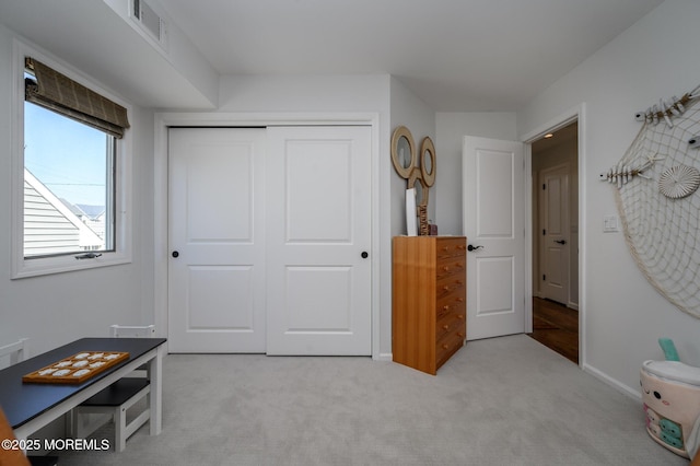 bedroom featuring baseboards, visible vents, a closet, and light carpet