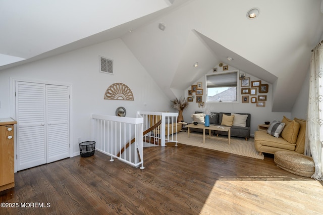 living room featuring lofted ceiling, wood finished floors, and visible vents