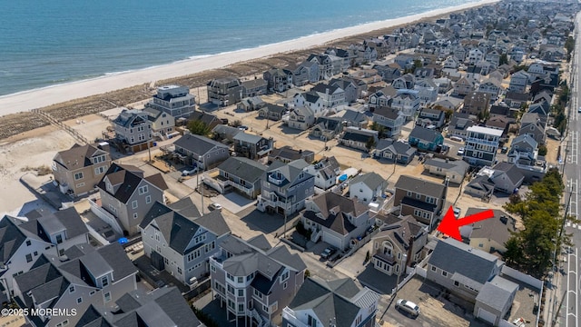 drone / aerial view featuring a residential view, a beach view, and a water view