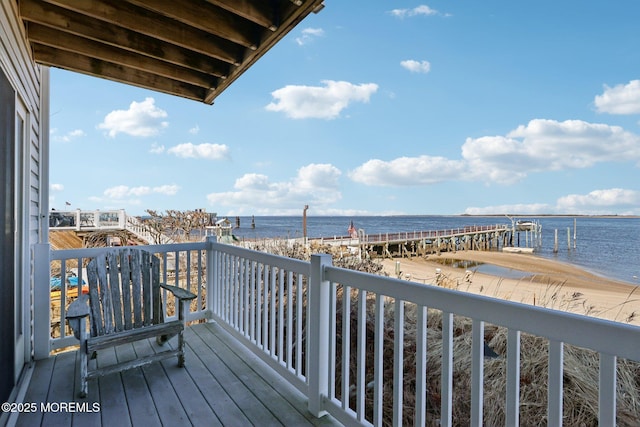 balcony with a water view and a view of the beach