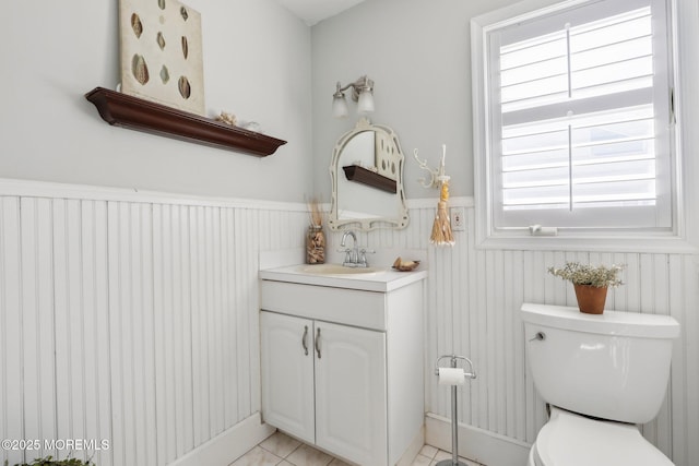 bathroom with vanity, toilet, and wainscoting