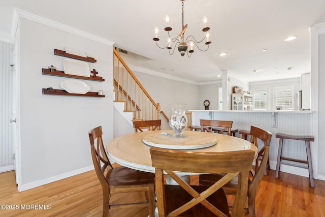 dining room with stairs, crown molding, light wood-style flooring, and baseboards