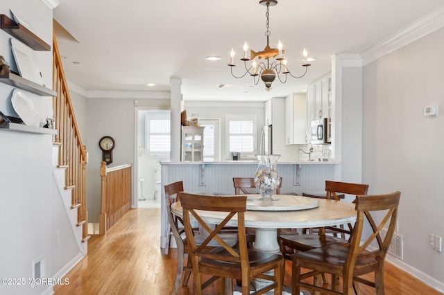 dining room with stairway, baseboards, crown molding, and light wood finished floors