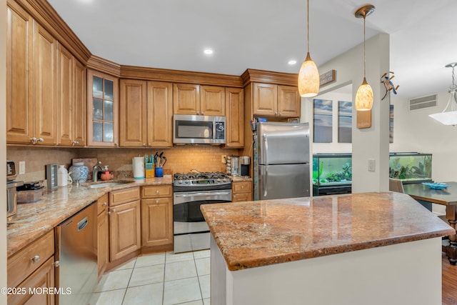 kitchen with visible vents, a sink, light stone counters, stainless steel appliances, and decorative backsplash