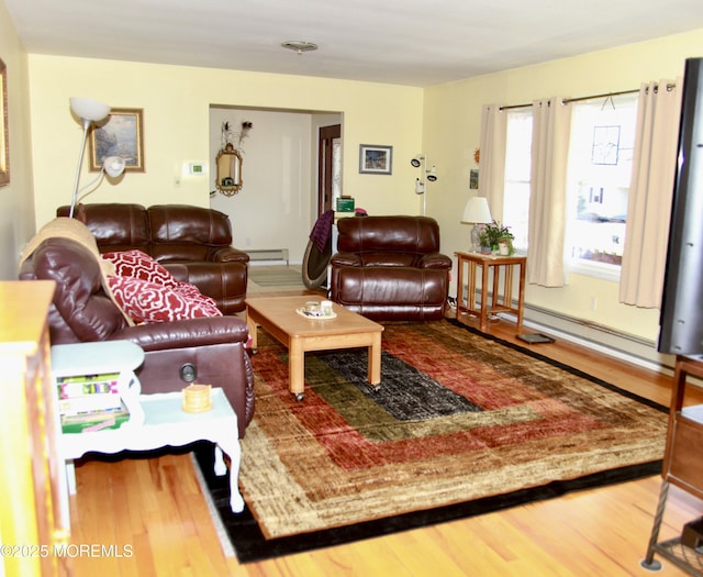 living area featuring a baseboard heating unit and wood finished floors