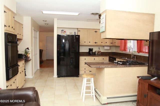 kitchen featuring a warming drawer, black appliances, a sink, dark countertops, and a peninsula