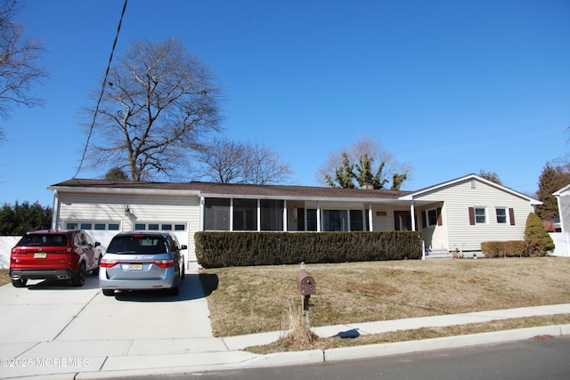 ranch-style home with concrete driveway, an attached garage, and a front lawn