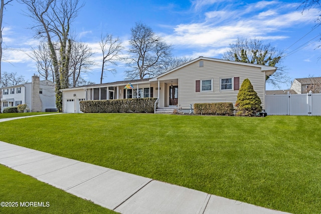 view of front of property featuring a front yard, fence, and a garage