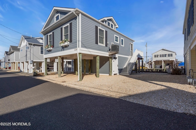 beach home with a carport, a residential view, driveway, and stairs