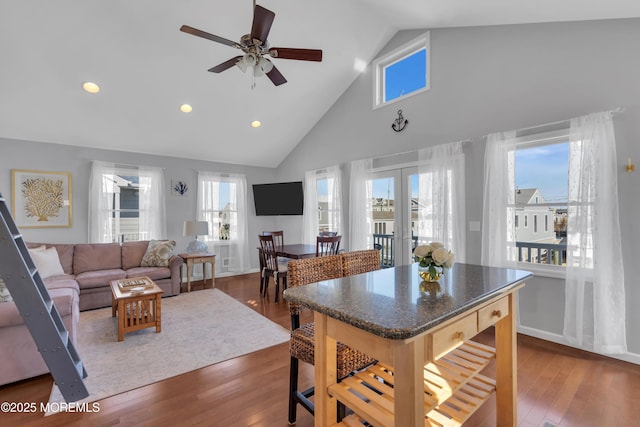 kitchen with dark countertops, recessed lighting, french doors, dark wood-style floors, and high vaulted ceiling