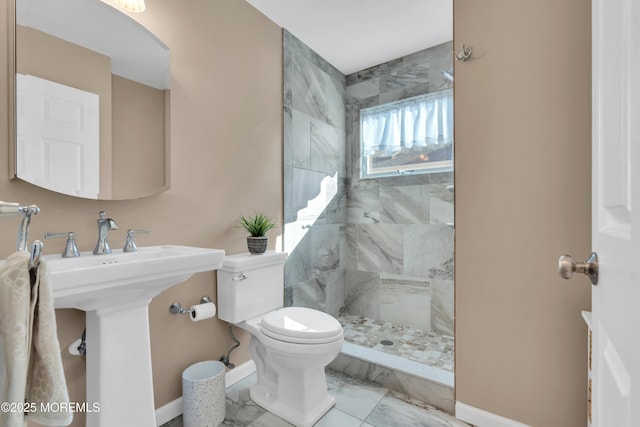 full bath featuring toilet, baseboards, marble finish floor, and a tile shower