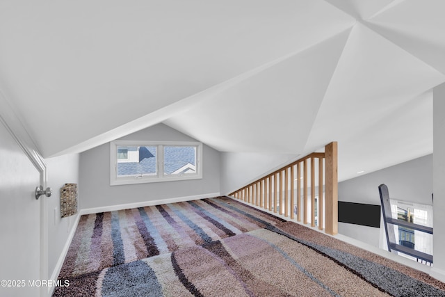 additional living space featuring carpet floors, baseboards, and vaulted ceiling