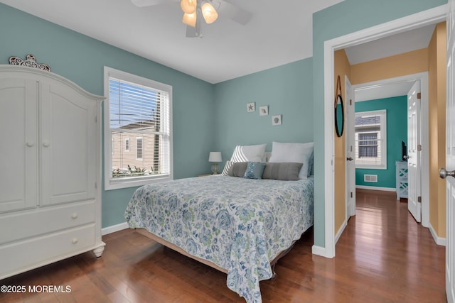 bedroom featuring dark wood-type flooring, visible vents, baseboards, and ceiling fan