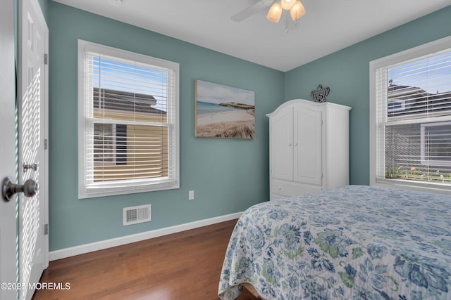 bedroom with dark wood finished floors, baseboards, visible vents, and a ceiling fan