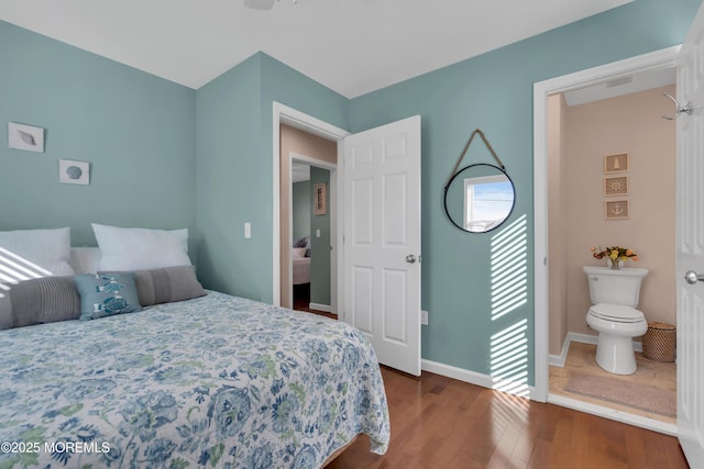 bedroom featuring visible vents, baseboards, and wood finished floors