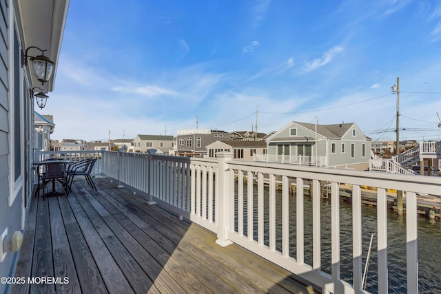 wooden deck with a residential view and a water view