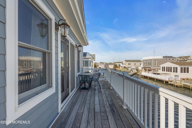 wooden terrace with a residential view and a water view