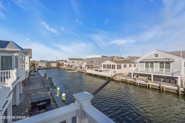 view of dock with a residential view and a water view