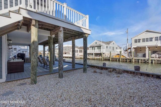 view of dock featuring stairway, a residential view, and a deck with water view