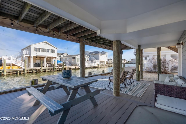 dock area featuring a deck with water view, a residential view, and outdoor lounge area