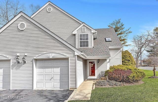 view of front of house featuring aphalt driveway, an attached garage, and a shingled roof