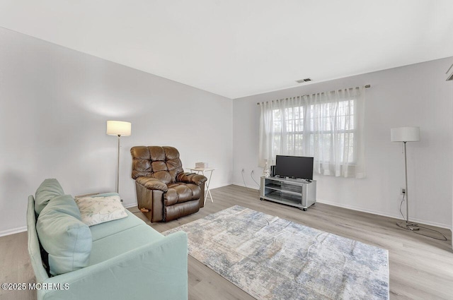 living area with visible vents, baseboards, and light wood finished floors