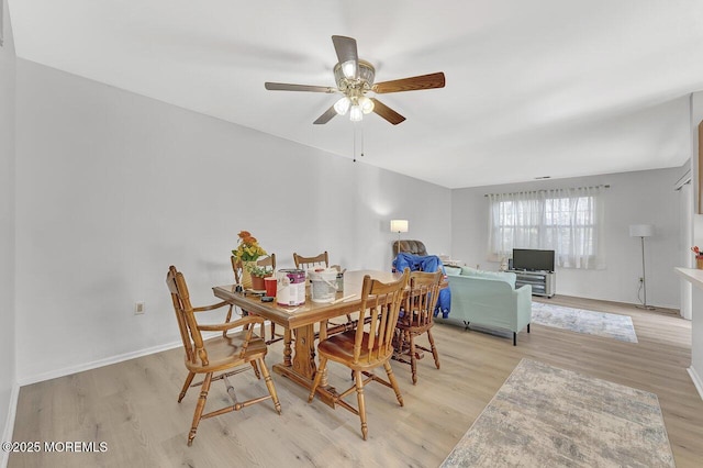 dining room featuring baseboards, light wood-type flooring, and ceiling fan