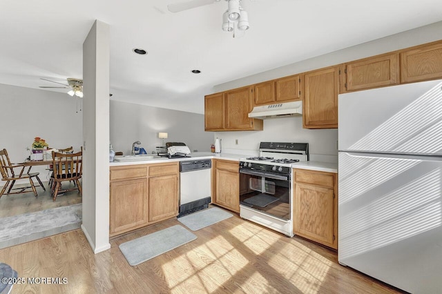 kitchen featuring light wood finished floors, a ceiling fan, under cabinet range hood, white appliances, and light countertops