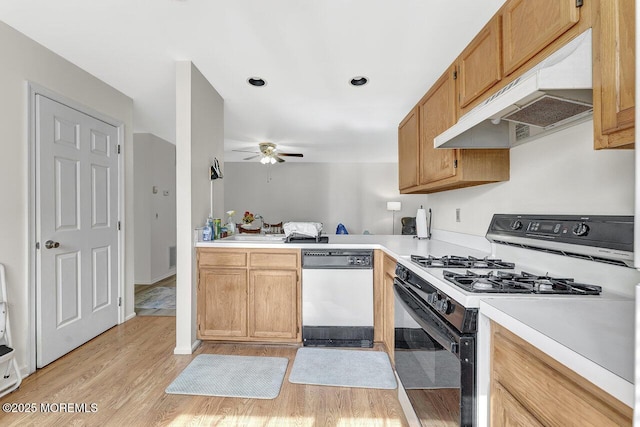 kitchen featuring range with gas cooktop, under cabinet range hood, light countertops, light wood-style floors, and white dishwasher