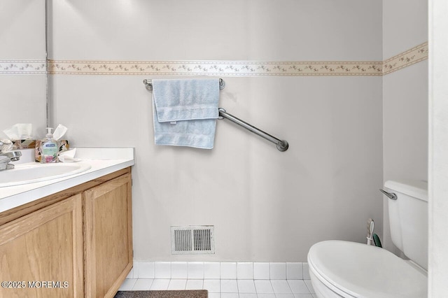 half bath with vanity, toilet, visible vents, and tile patterned flooring