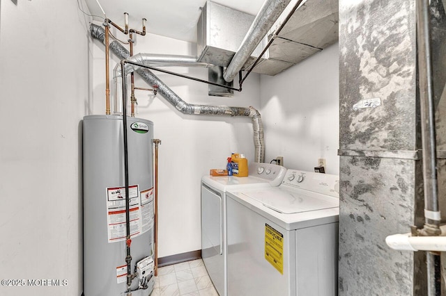 washroom featuring washing machine and dryer, gas water heater, laundry area, and marble finish floor