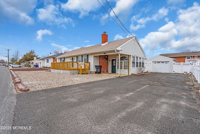 3172 Peddie St, Toms River, NJ 08753 - view of front of house with a chimney, a wooden deck, an outbuilding, fence, and aphalt driveway