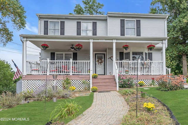 view of front of house featuring a porch, a ceiling fan, and a front lawn