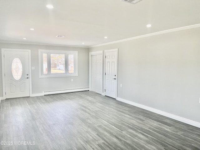 foyer entrance with a baseboard heating unit, baseboards, wood finished floors, and crown molding