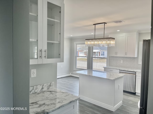 kitchen with visible vents, ornamental molding, stainless steel appliances, white cabinetry, and backsplash