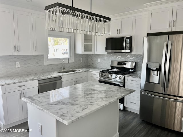 kitchen featuring a sink, tasteful backsplash, appliances with stainless steel finishes, and white cabinetry