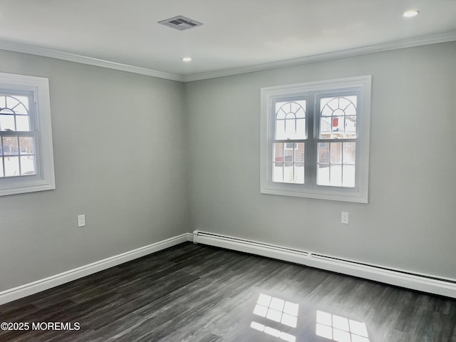 spare room featuring visible vents, dark wood-type flooring, crown molding, baseboards, and baseboard heating