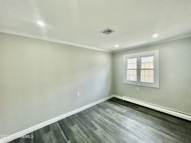 spare room with visible vents, baseboards, ornamental molding, baseboard heating, and dark wood-style floors