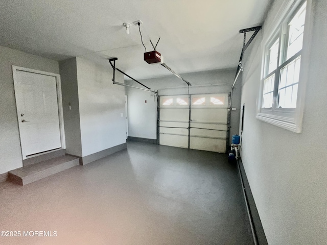 garage with a garage door opener and baseboards