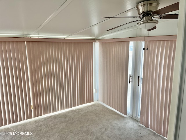 carpeted empty room featuring a ceiling fan and lofted ceiling