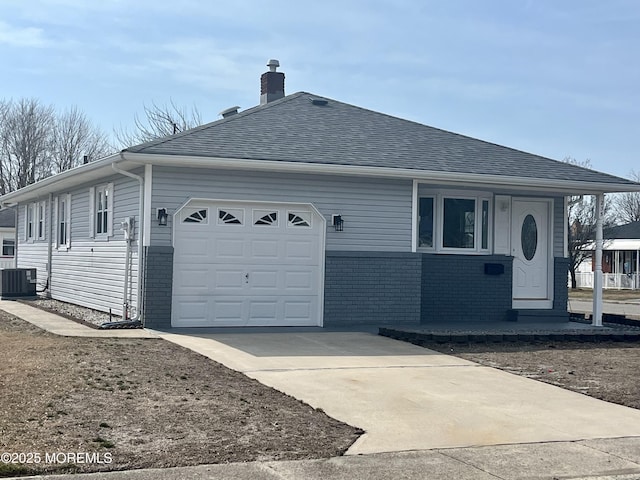 ranch-style home with a chimney, brick siding, central AC unit, and an attached garage