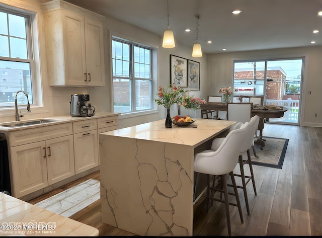 kitchen with a sink, a kitchen breakfast bar, recessed lighting, and a wealth of natural light