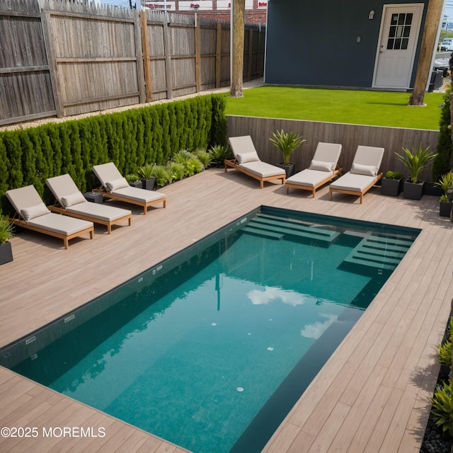 view of swimming pool featuring a fenced in pool, fence, a wooden deck, and a lawn