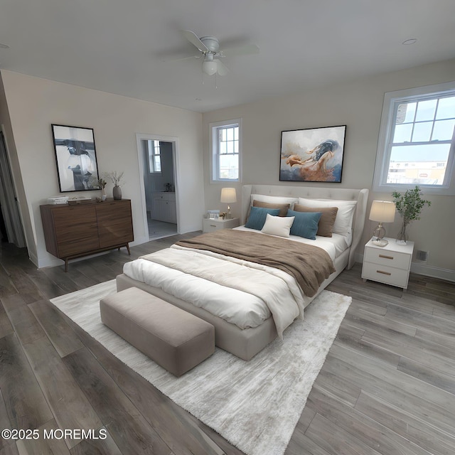 bedroom with ceiling fan, baseboards, ensuite bathroom, and wood finished floors