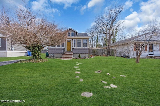 view of front facade with a front lawn and fence