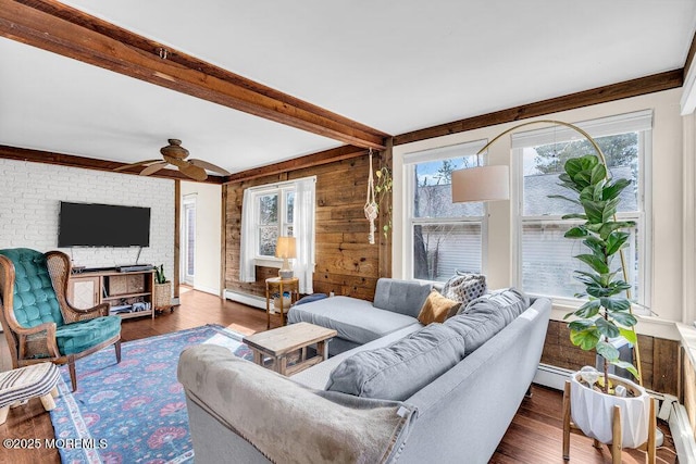 living area featuring dark wood-style floors, beamed ceiling, a healthy amount of sunlight, and baseboard heating