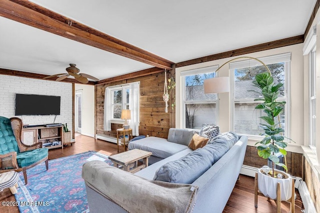 living room featuring beamed ceiling, baseboard heating, ceiling fan, and wood finished floors