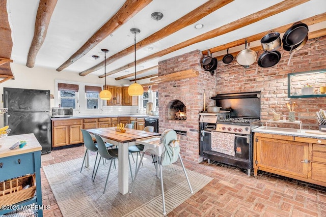 dining space with beam ceiling, brick floor, and brick wall