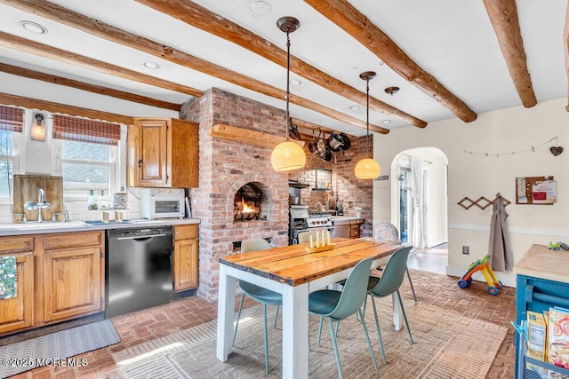 kitchen featuring brick floor, arched walkways, a sink, light countertops, and dishwasher