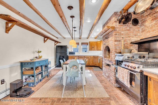 interior space with beamed ceiling, appliances with stainless steel finishes, light countertops, brick floor, and a baseboard radiator